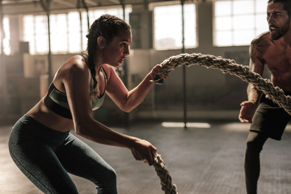 a woman working out with battle ropes