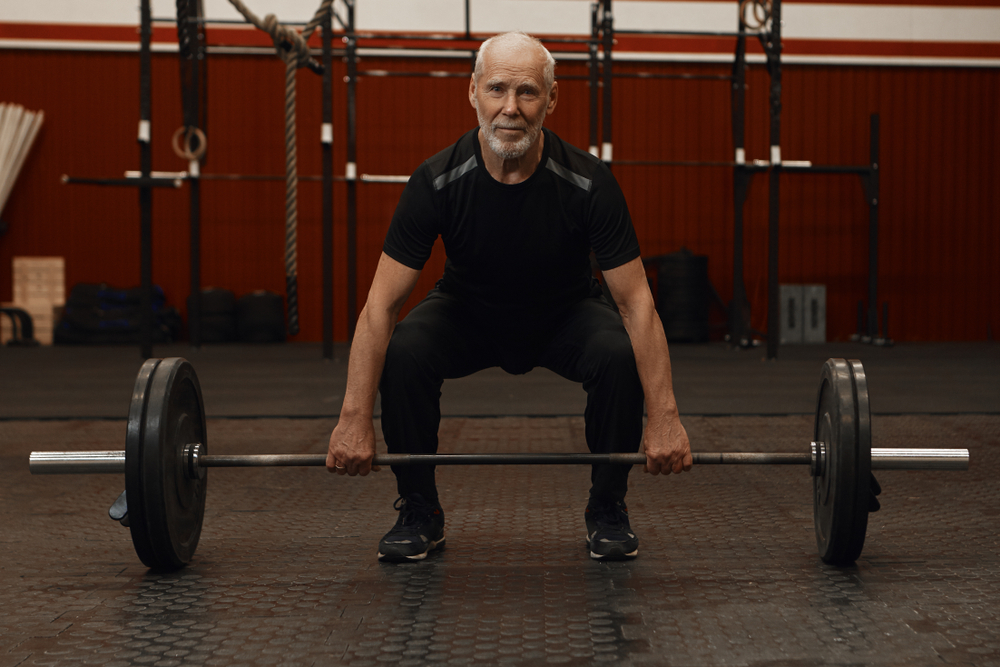 an older man with white hair lifting weights