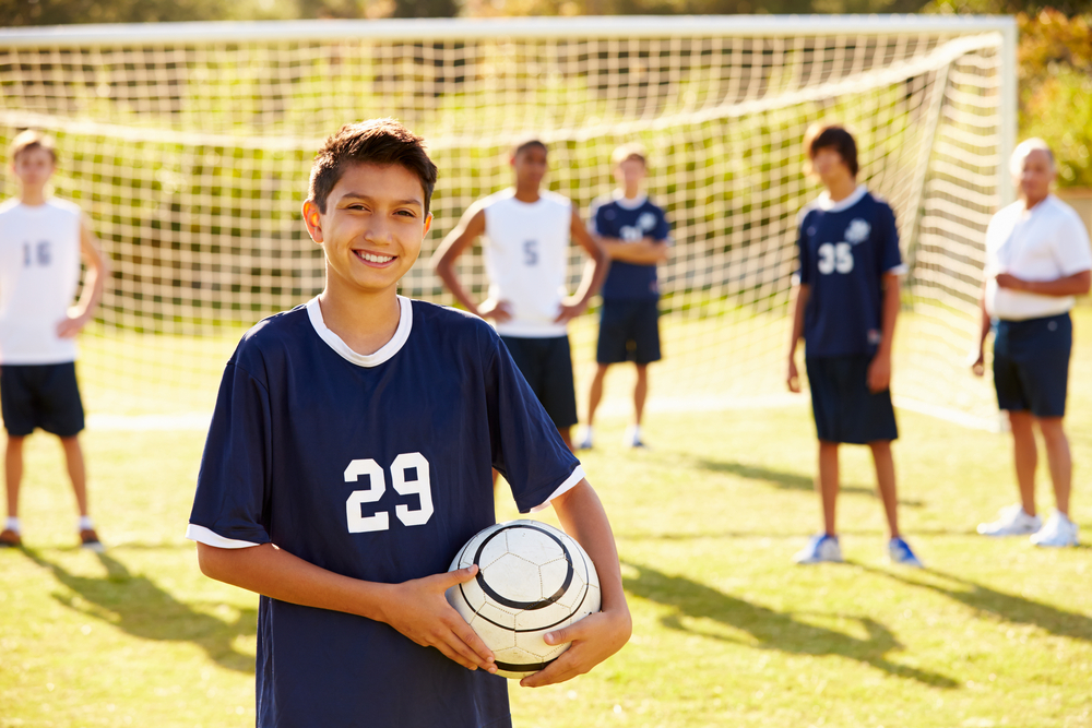 teen boy holding soccer ball