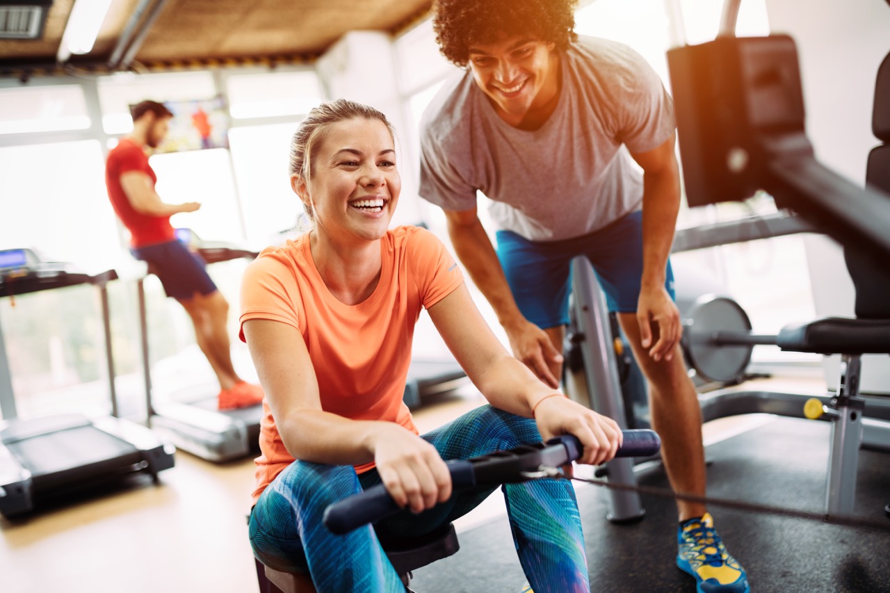 woman in gym works with trainer