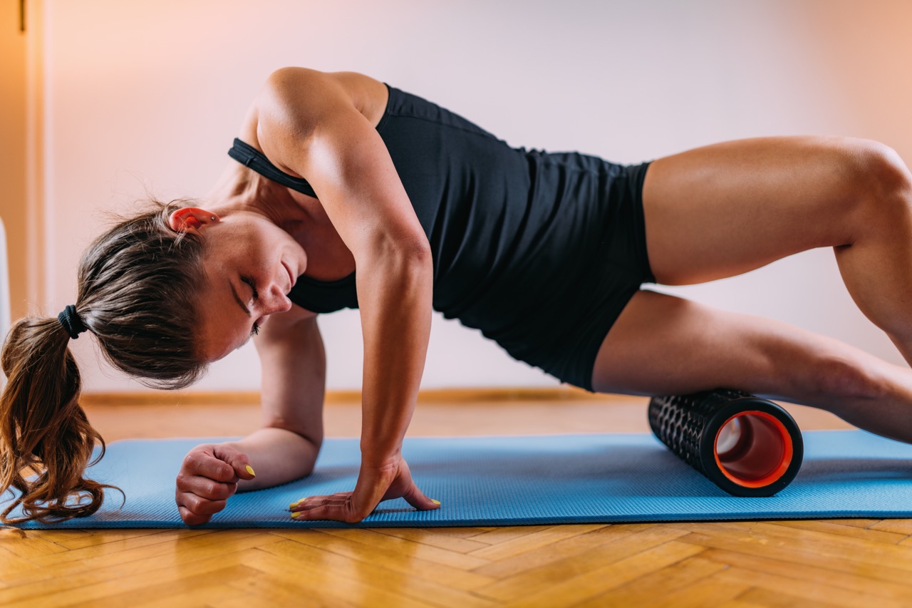 woman stretches on a foam roll