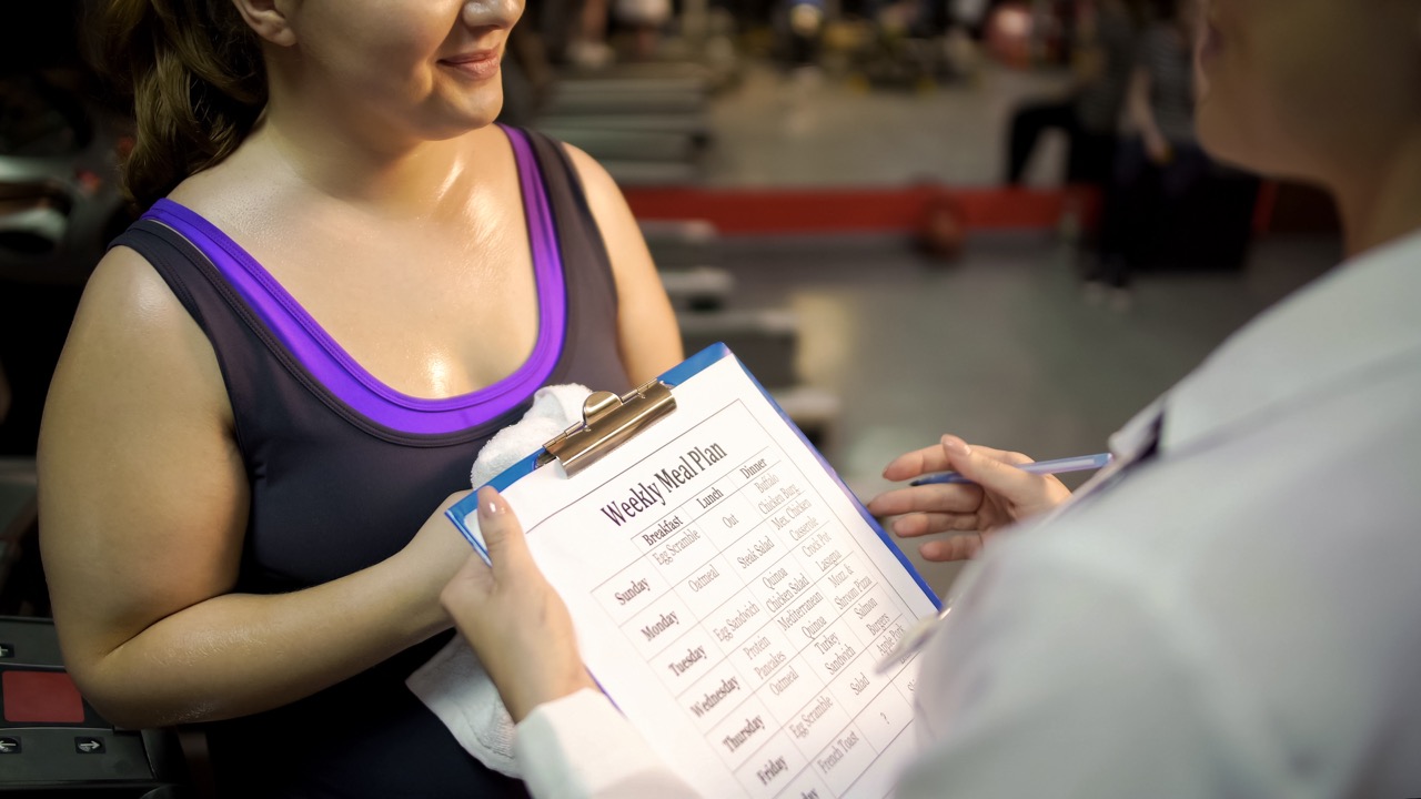 woman talking to trainer about weight loss plan