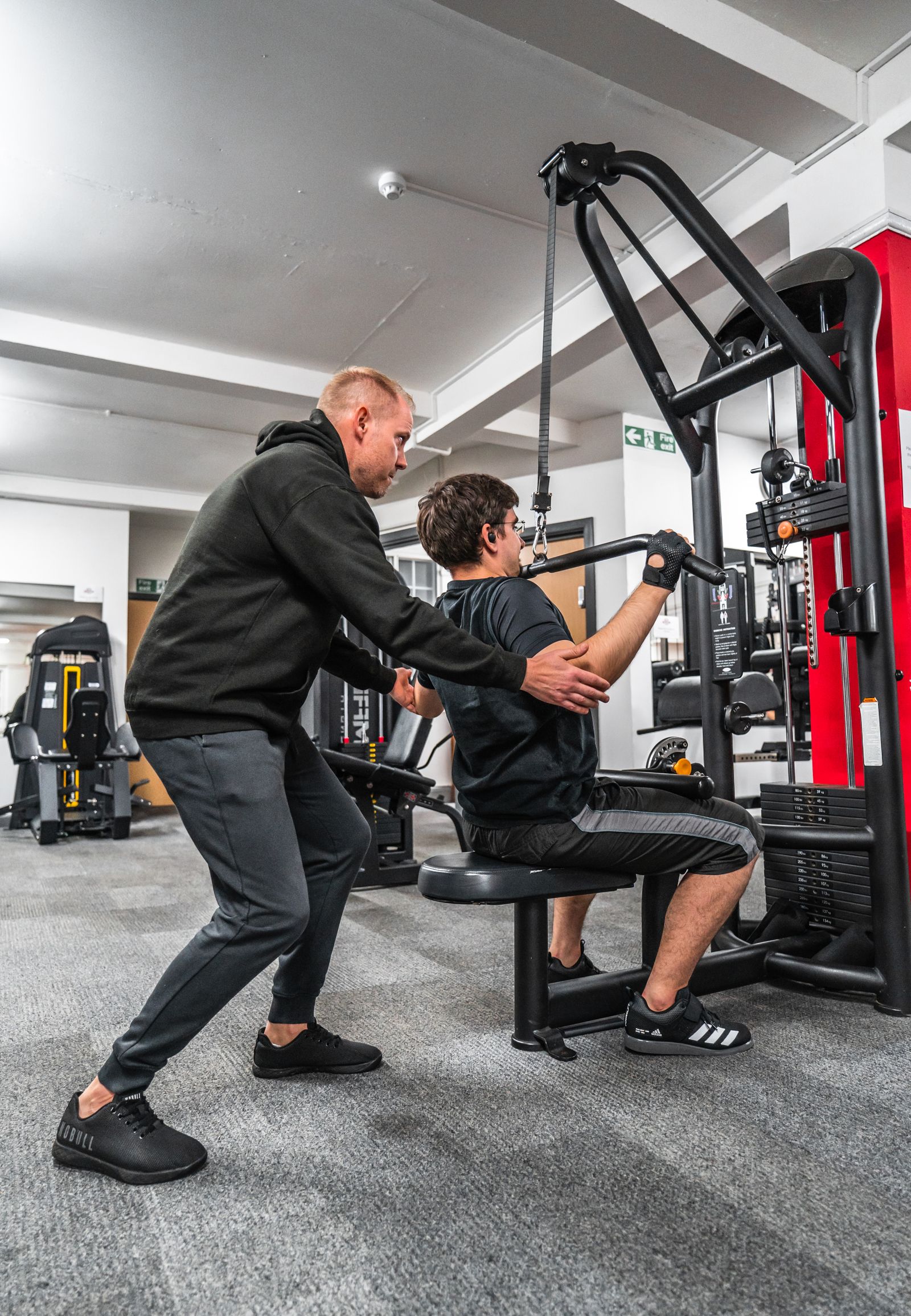 A coach working one-on-one with a client in a calm, private-feeling gym studio