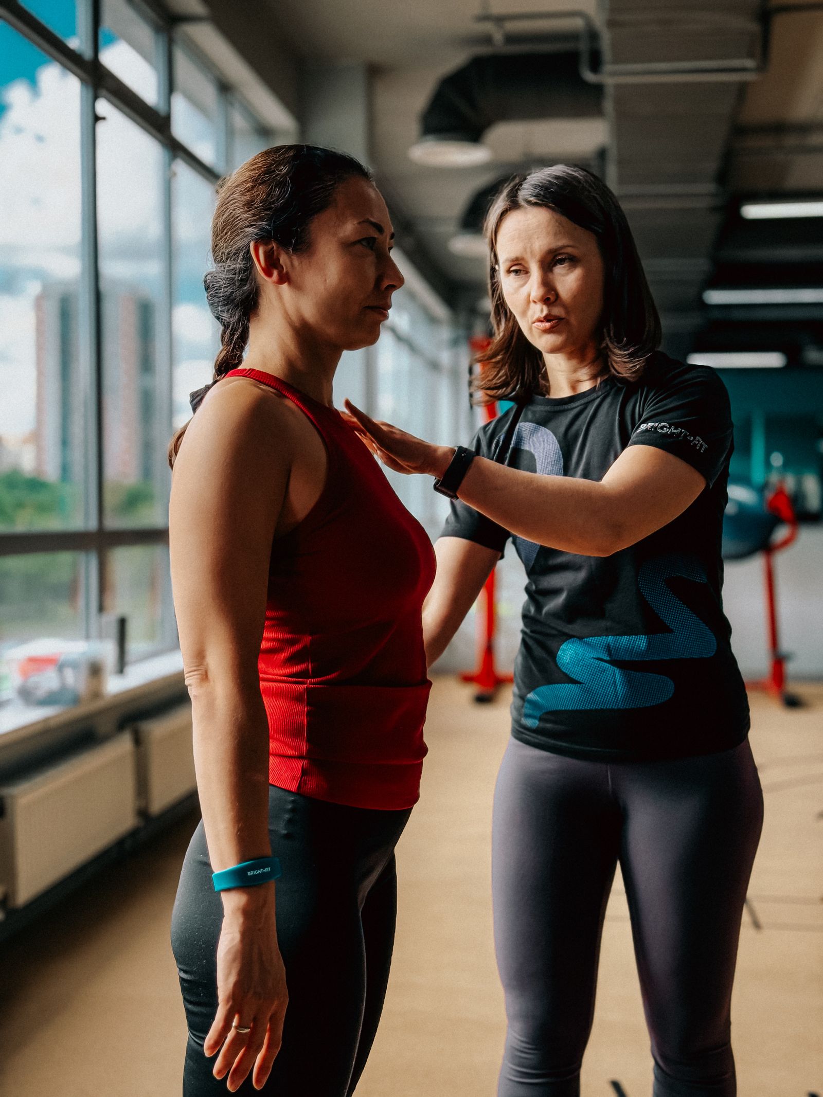 A weight loss coach guides a client one-on-one in a bright, private-feeling fitness studio in Draper